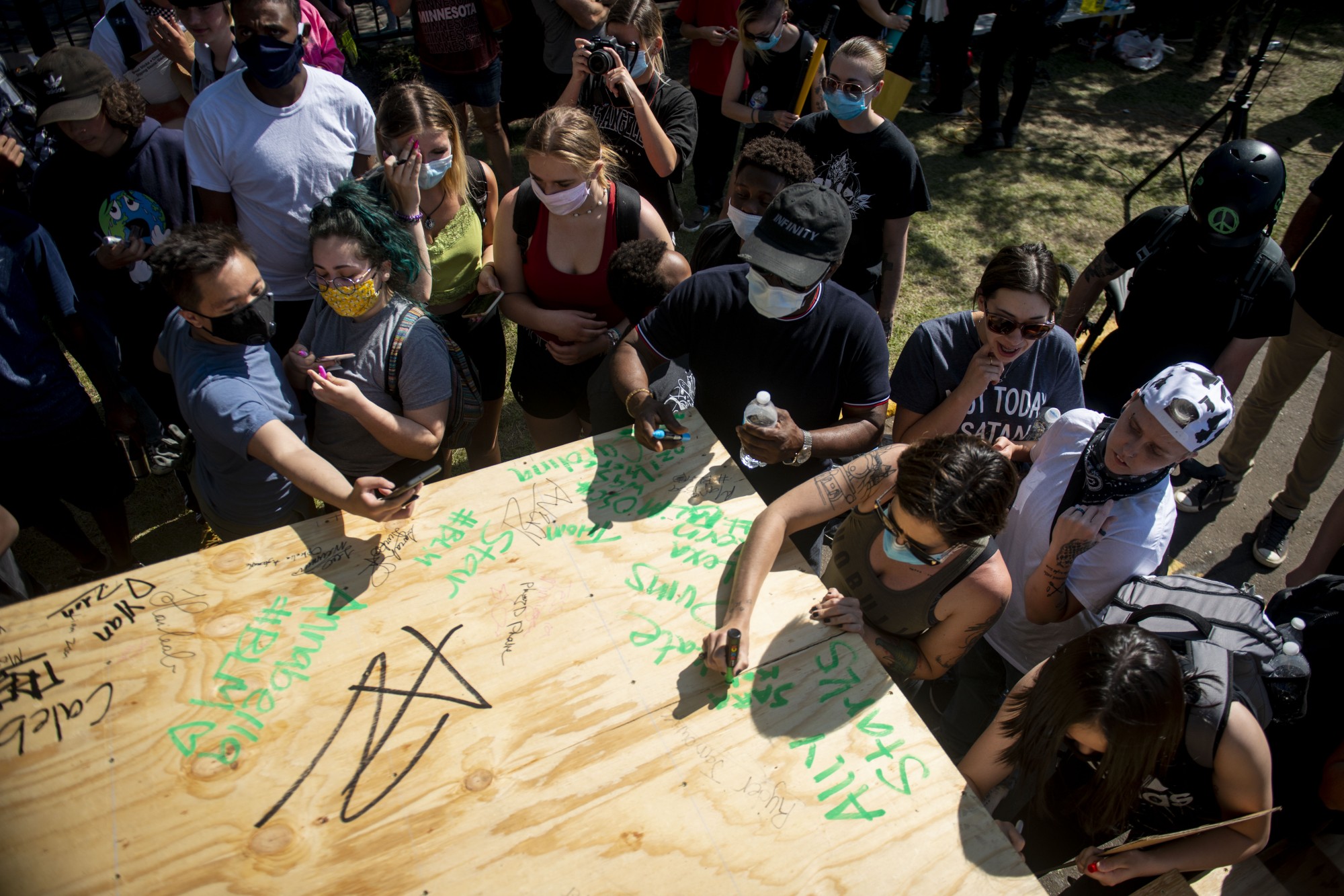 Attendees signed their names to complete a stage constructed near the intersection of East Lake Street and 26th Avenue South on Sunday, May 31. The stage was for speakers to amplify their voices, and organizer Cornell Griffin had volunteers help complete the final steps.
