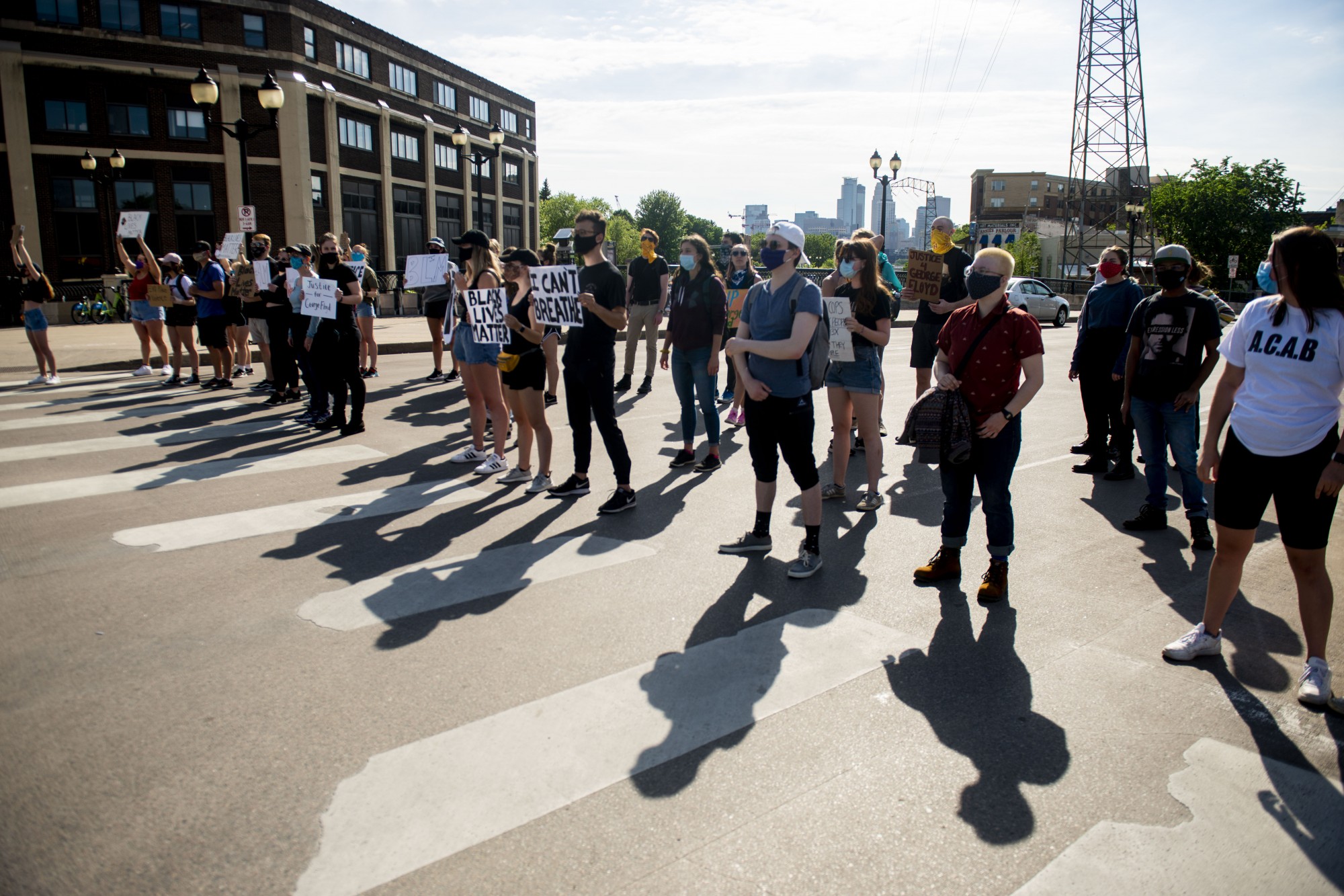 Students protest at the entrance of Dinkytown, blocking traffic from passing through on Southeast 4th Street on Sunday, May 31. Cars passing by frequently honked in support of the crowd.
