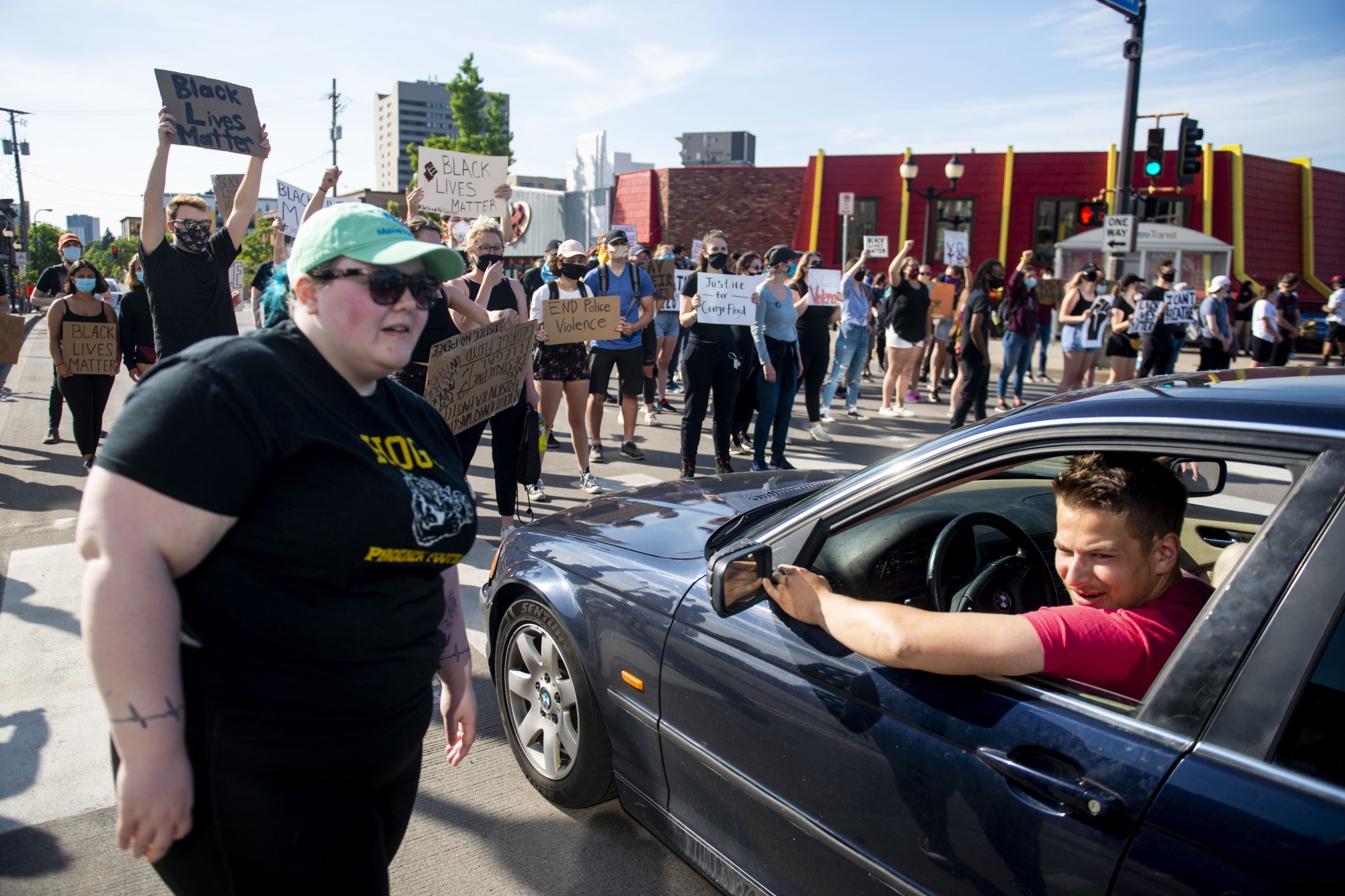 Students protest at the entrance of Dinkytown blocking traffic from passing through on SE 4th St on Sunday, May 31. Cars passing by frequently honked in support of the crowd. 