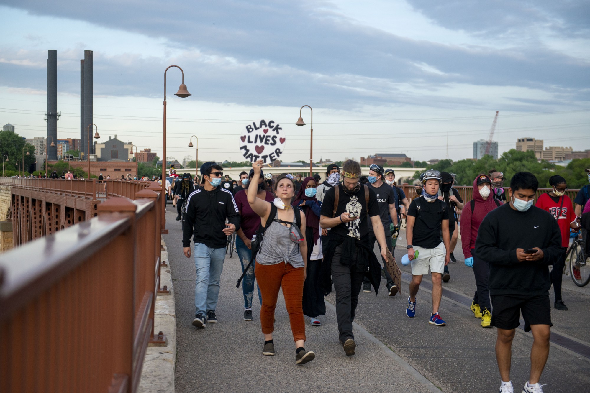 Demonstrators make their way through parts of campus as curfew nears, eventually crossing the Stone Arch Bridge and into downtown on Sunday, May 31.