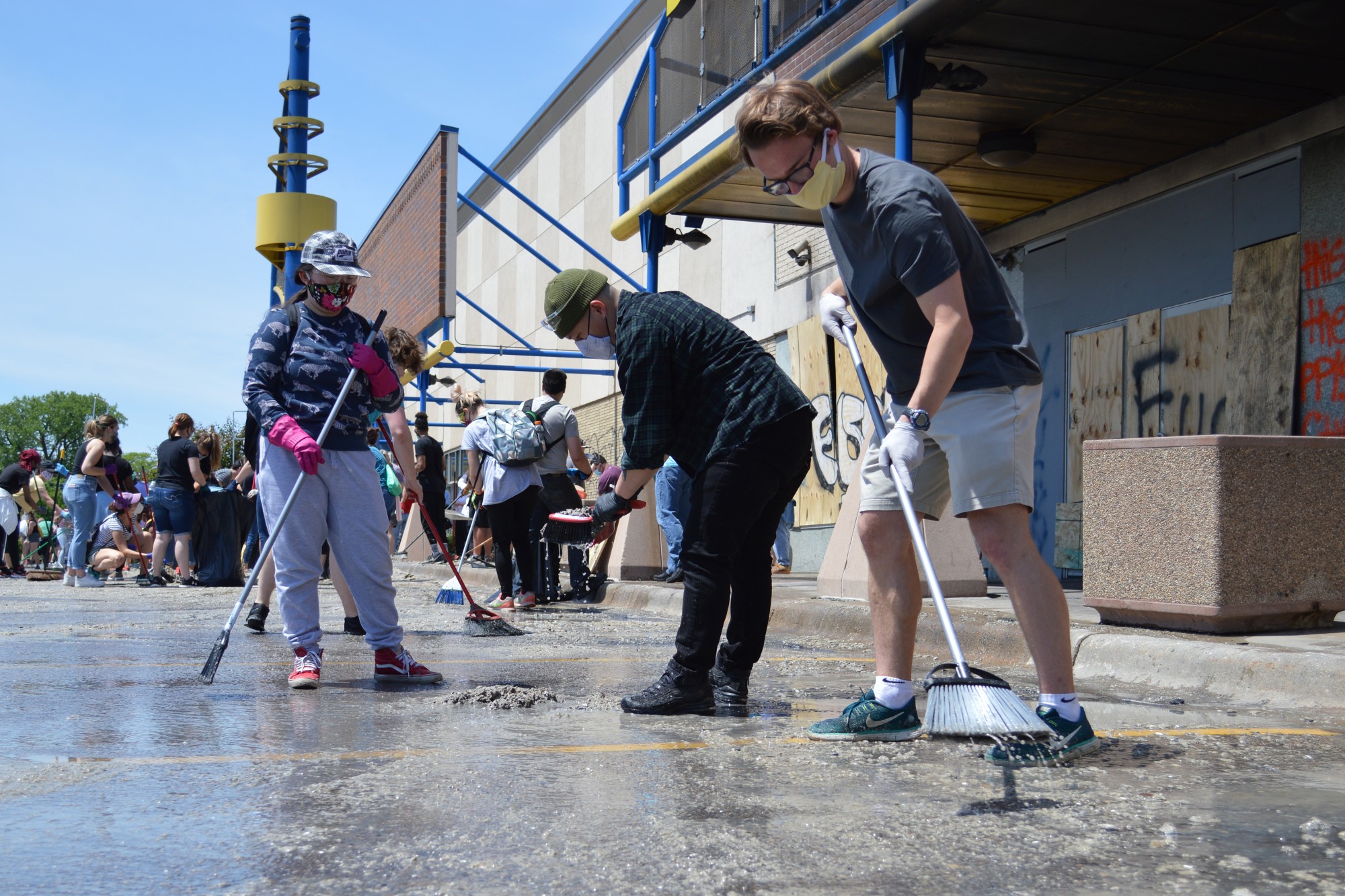 Jackson Hampton, right, works near the Hi-Lake Shopping Center in East Lake Street, just a few blocks from the Minneapolis Third Police Precinct, to help clear debris from the burned-down businesses on Sunday, May 31. 