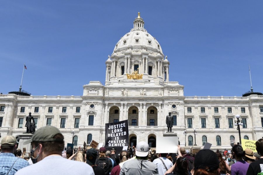 A banner that says “Justice long delayed is justice denied” is raised in front of the Minnesota State Capitol by demonstrators on May 31, 2020.