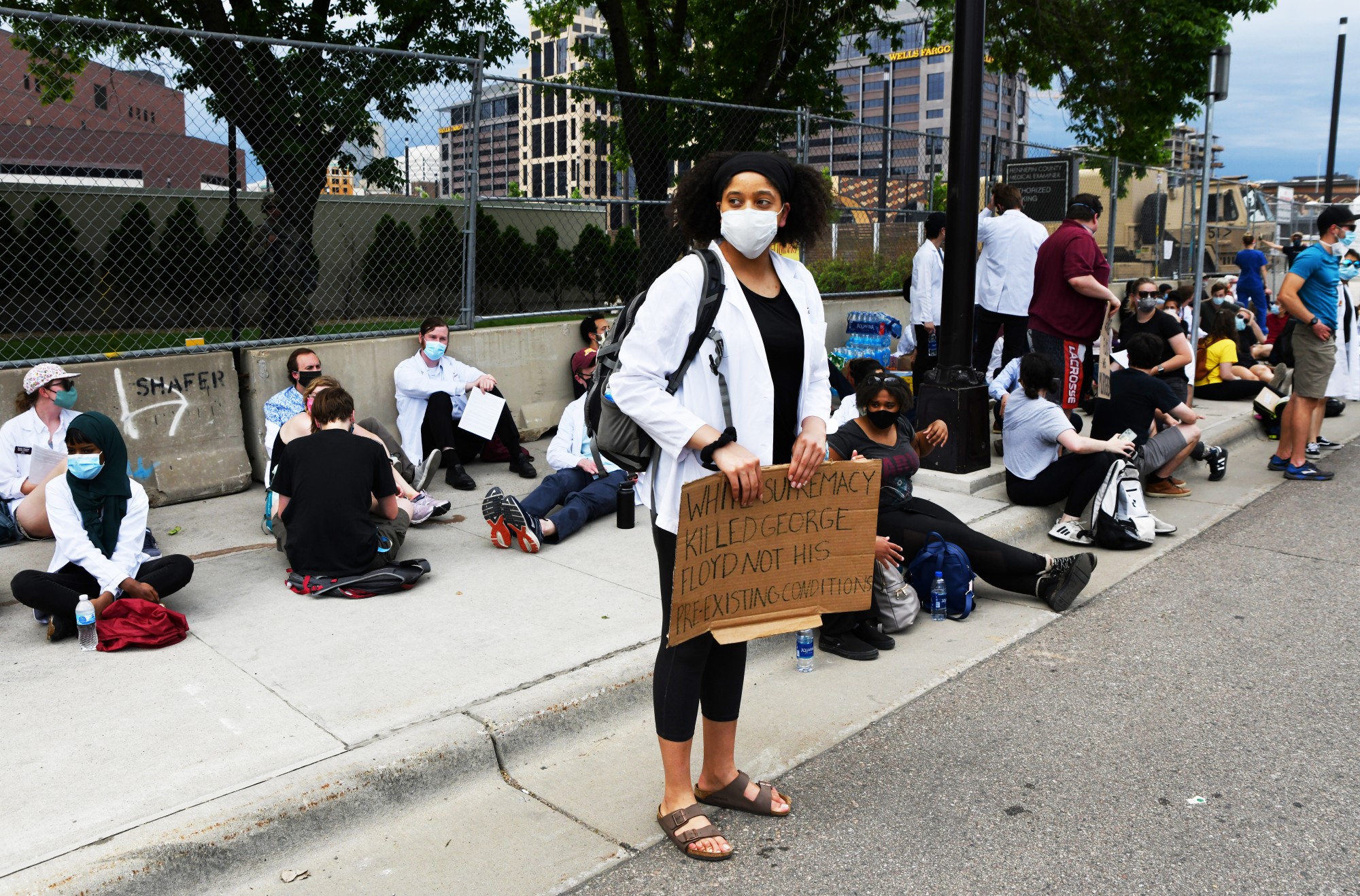 Dominique Earland, a first-year MD-Ph.D. student at the University of Minnesota Medical School, holds a sign that reads “White Supremacy Likked George Floyd Not His Preexisting Conditions” outside of the Hennepin County Medical Examiner’s office on Tuesday, June 2. Earland is one of several organizers of the medical students’ and medical professionals’ protest against the medical examiner’s preliminary report on the autopsy of George Floyd. 
