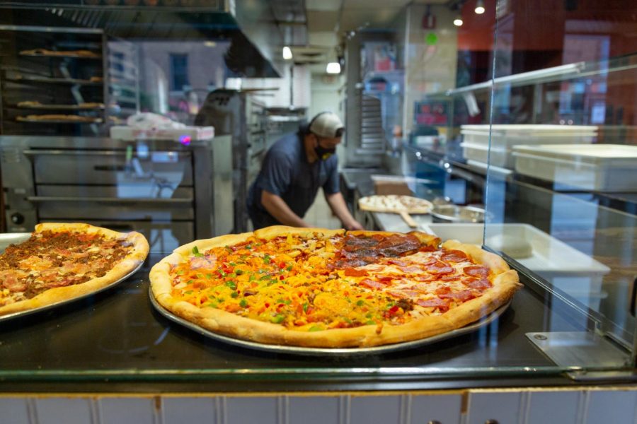 Mesa Pizza remains a popular Dinkytown destination amid the pandemic. They offer a unique selection of pizza by the slice. Workers prepare food, wearing masks and practicing social distancing, on Saturday, Sep. 12.