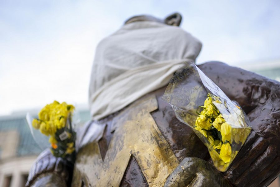 A cloth mask and bouquet of flowers are seen on the Goldy statue outside Coffman Memorial Union on Wednesday, April 1. (Parker Johnson / Minnesota Daily)