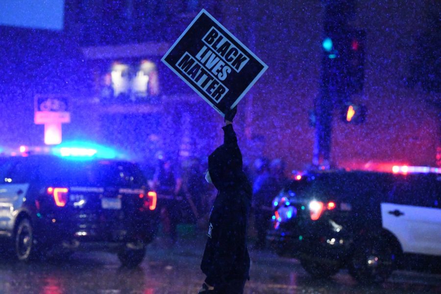A protester holds up a Black Lives Matter sign in front of the Minneapolis 3rd Police Precinct on Minnehaha Avenue on Tuesday, May 26. The protest was in response to the killing of George Floyd. 