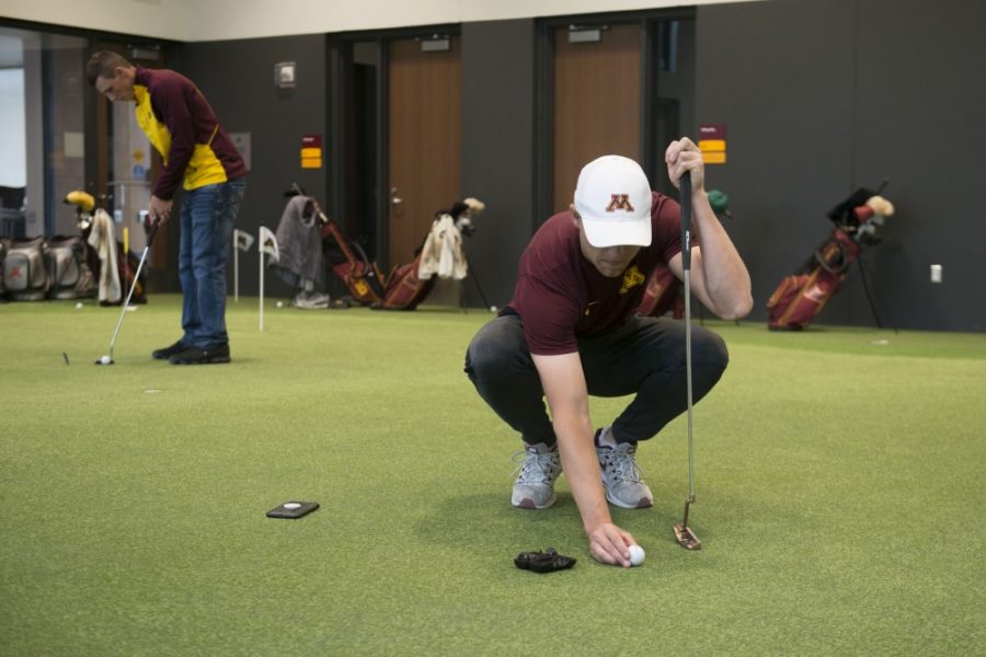 Thomas Longbella lines up a shot on the putting green in the indoor golf training facility in April 2019. The facility borders the Les Bolstad Golf Course and allows for practice throughout winter months.