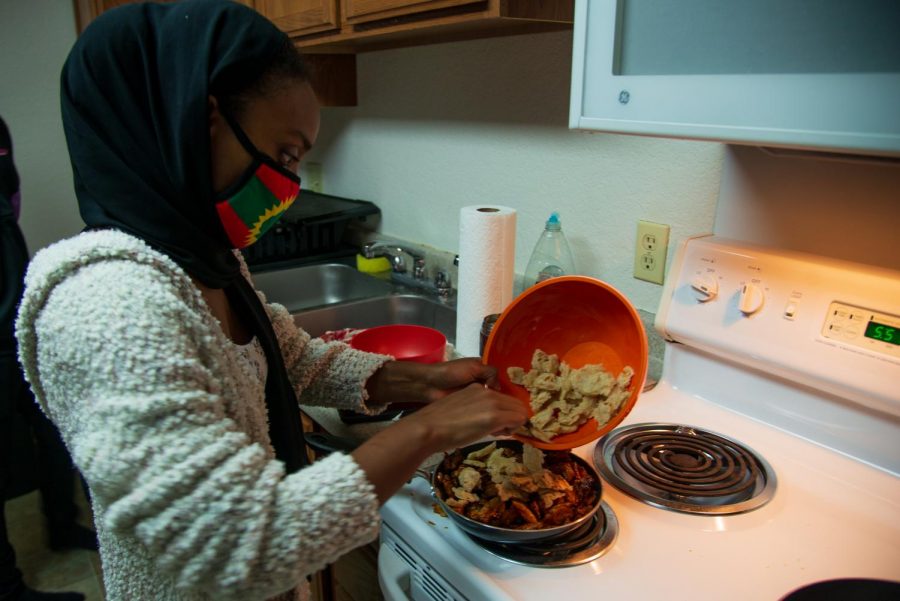 Oromo Student Union member Zubeda Chaffe cooks Caccabasa at the Keeler Apartments on Saturday, Oct. 24. Chaffe is combining bread with a sauce made of butter and spices.