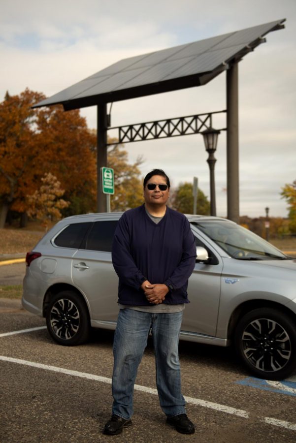 Bob Blake, the founder and CEO of Solar Bear Solar Panel Installation Services, poses for a portrait by his hybrid car parked at an electric vehicle charging station at the Como Lakeside Pavilion on Sunday, Oct. 11. He started Solar Bear in hopes of doing his part for the environment.