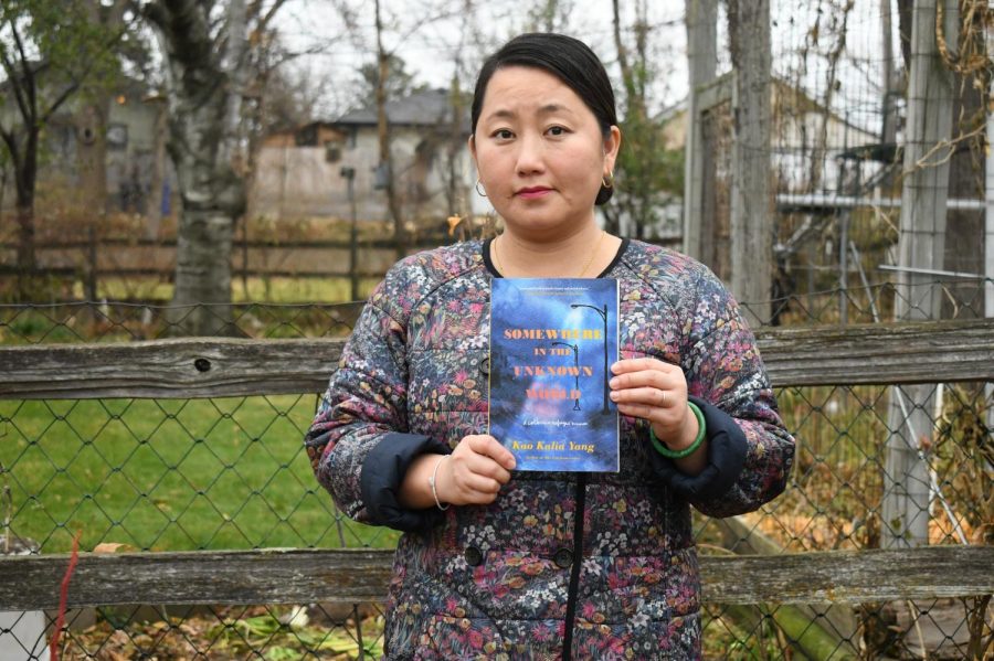 Author Kao Kalia Yang poses in her backyard with her most recent book, “Somewhere in the Unknown World” on Monday, Nov. 9. Yang will appear at the Immigration History Research Center and the International Rescue Center’s virtual event on Nov. 16 to discuss her new work, which features the stories of refugees in Minnesota.