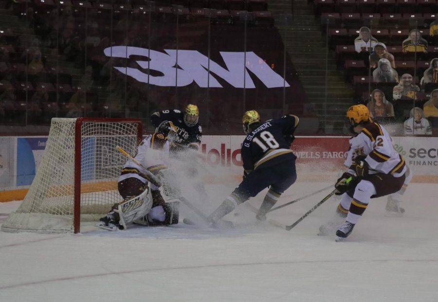 Minnesota’s goalie Jack LaFontaine blocks an attempted goal from Notre Dame’s Graham Slaggert on Saturday, Jan. 16 at the 3M arena at Marriucci.