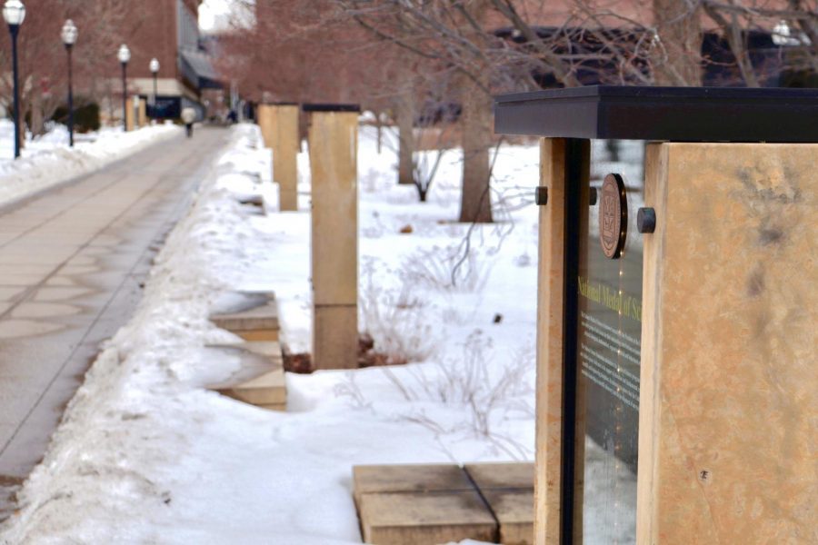 A plaque listing names of accomplished alumni and faculty on Scholars Walk on Wednesday, Feb. 23. Some students are leading a push to have Black journalist and civil rights activist Marvel Cooke added to the iconic walkway on campus.