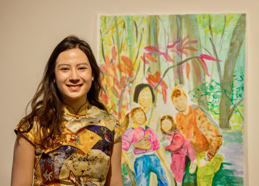 Anika Schneider poses for a portrait with a painting of an old family photo on Thursday, March 18 at the Soo Visual Arts Center in Minneapolis. Schneider often uses old family photos as references and inspiration for her own paintings, etchings and collage pieces.
