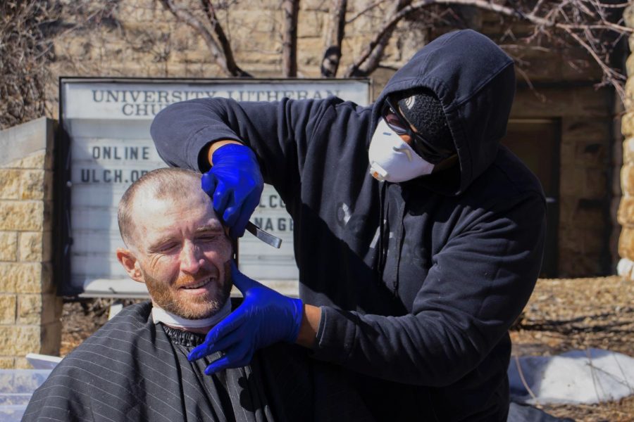 Stylist Jared Swanegan trims Tim Krolseks beard in front of the University Lutheran Church of Hope on Saturday, March 6. The church hosted a drop-in event for unhoused people, offering free haircuts, hot meals, jackets and supplies.