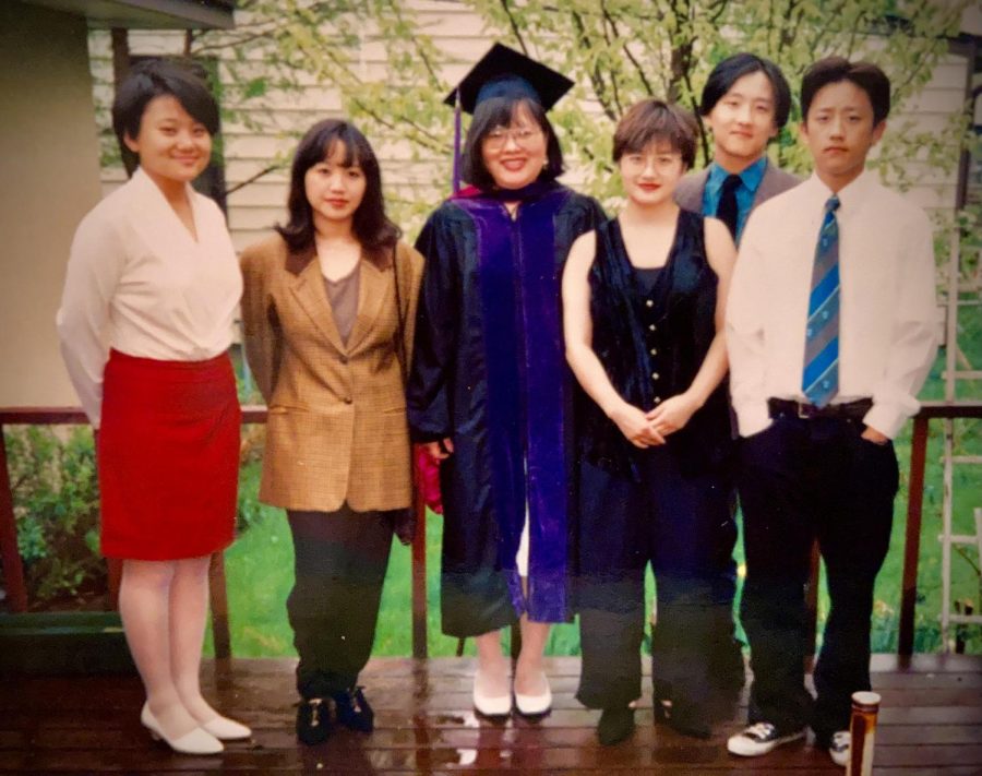 Ilean stands in the center in her graduation gown.