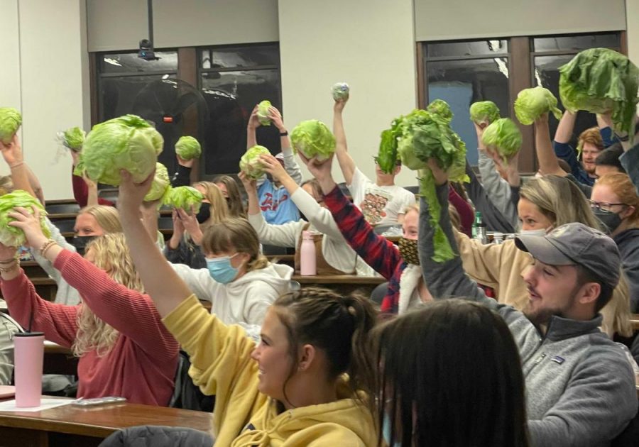Students participating in the fall 2021 lettuce eating competition raise their heads of lettuce in the air. The meeting, hosted by the University of Minnesota Lettuce Club, is semi-annual. 