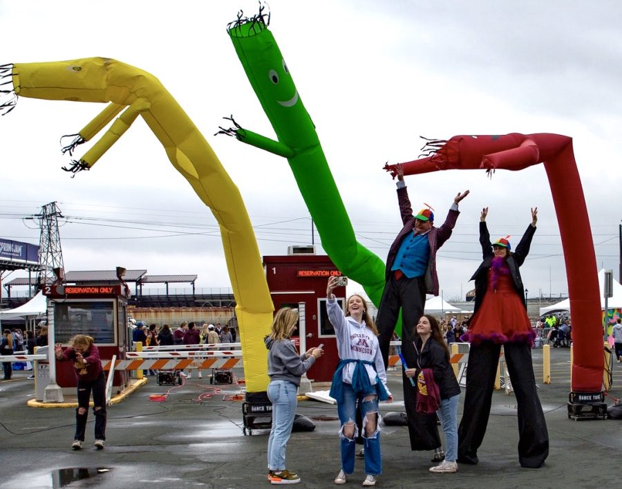 Students pose for a selfie with entertainers on stilts at the Spring Jam Festival on Saturday, April 30. The 2022 Festival was the first that the University of Minnesota has held since 2019.