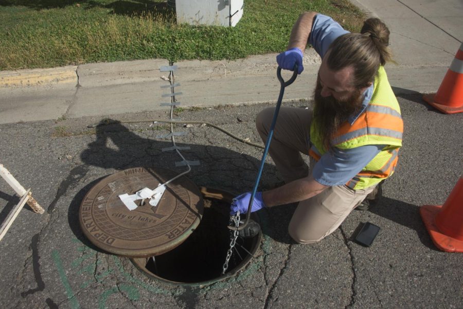 Met Council employee Nick Alverson checks for flammable and hazardous gasses inside a sewer maintenance hole on the University of Minnesota campus. An electric monitor at the site is among the safeguards in place to reduce the likelihood of evacuations in the future.