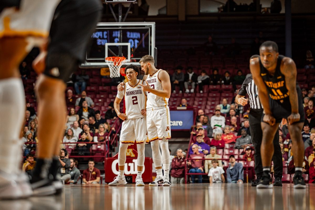 Mike+Mitchell+and+Parker+Fox+on+the+Gopher+mens+basketball+team+talking+through+the+game+during+a+free+throw+on+Monday%2C+Nov.+6+2023+at+Williams+Arena.