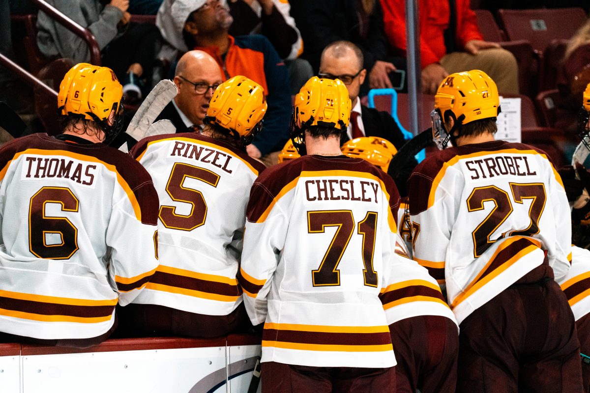 Minnesota Gophers (from left to right) Cal Thomas, Sam Rinzel, Ryan Chesley, and Charlie Strobel gather around Coach Bob Motzko to discuss strategy during a timeout. The No. 14 Wisconsin Badgers would go on to beat the No. 1 Minnesota Gophers 5-2 on Thursday, October 26th.