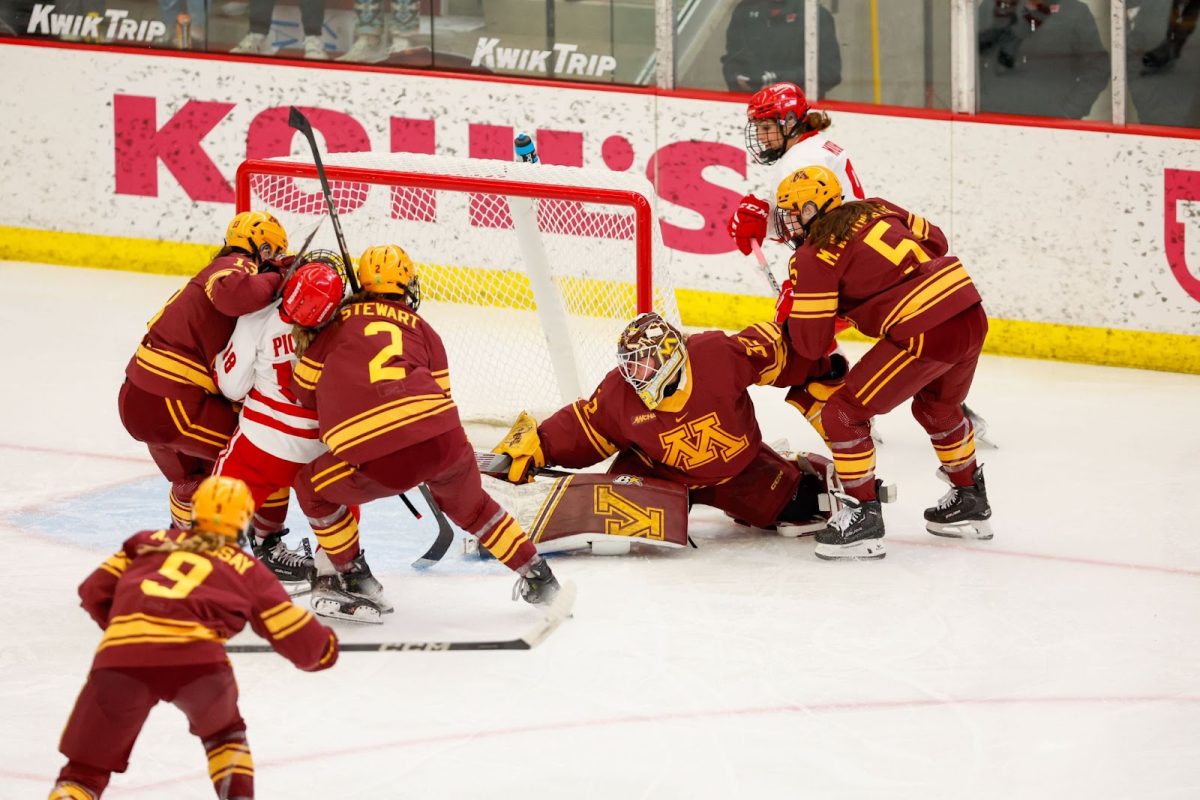 Gopher goaltender Lucy Morgan attempts to locate the puck in a net-front scramble during Saturday afternoon’s 4-0 loss. Morgan had 27 saves and allowed one power-play goal in the loss.