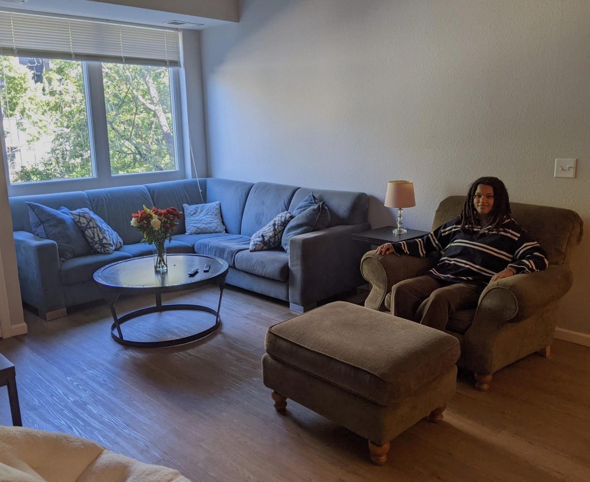 University sophomore Xaria Williams sits in her living room at Radius Apartments in Dinkytown, which she collaboratively decorated with her roommates.