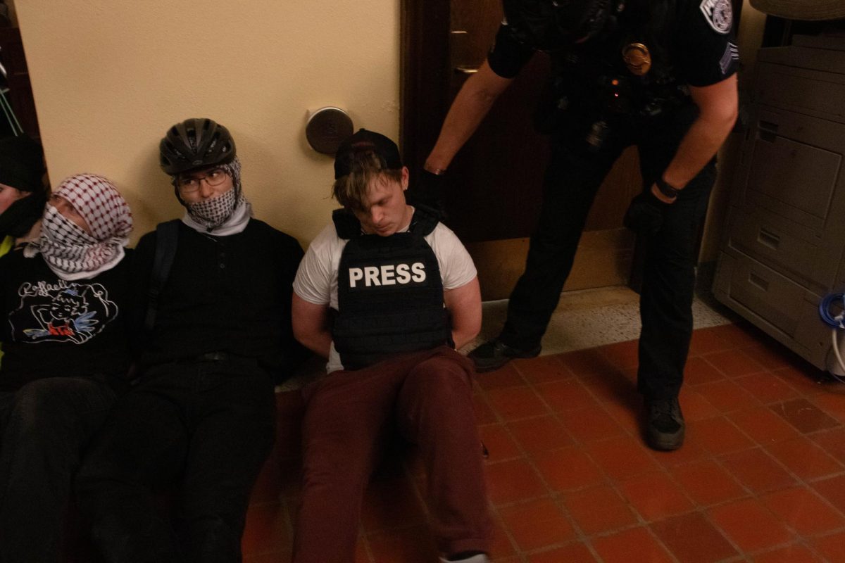 Church, in his press vest, detained by UMPD.