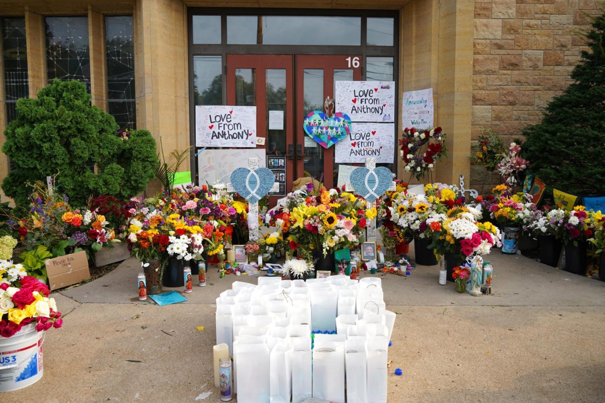 A community-built memorial honoring Fletcher Merkel and Harper Moyski, the 8 and 10 year olds killed in a shooting at Annunciation Catholic School, sits in front of the school.