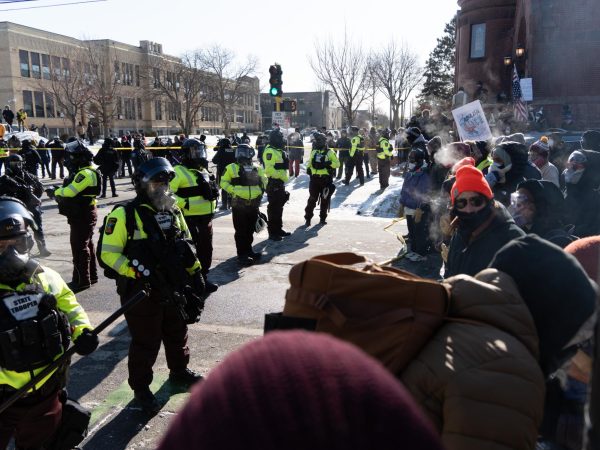 Law enforcement officers from various city and state departments manage the crowd of protesters at the corner of West 26 St. and Blaisdell Ave. following the death of Alex Pretti.