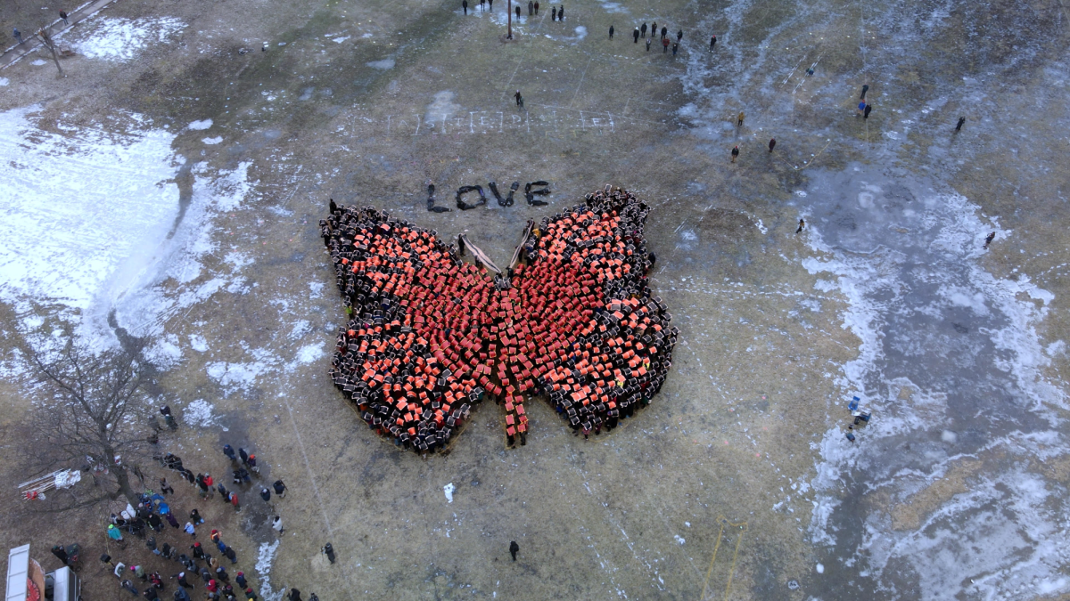 A butterfly designed by Big Animal Production using 1,000 individuals  holding multicolored posters at Kaleidoscope of Love on Feb. 28, 2026. This event was held to showcase resistance to the presence and actions of federal immigration agents in recent months. | Courtesy of Big Animal Productions, Christopher Lutter-Gardella