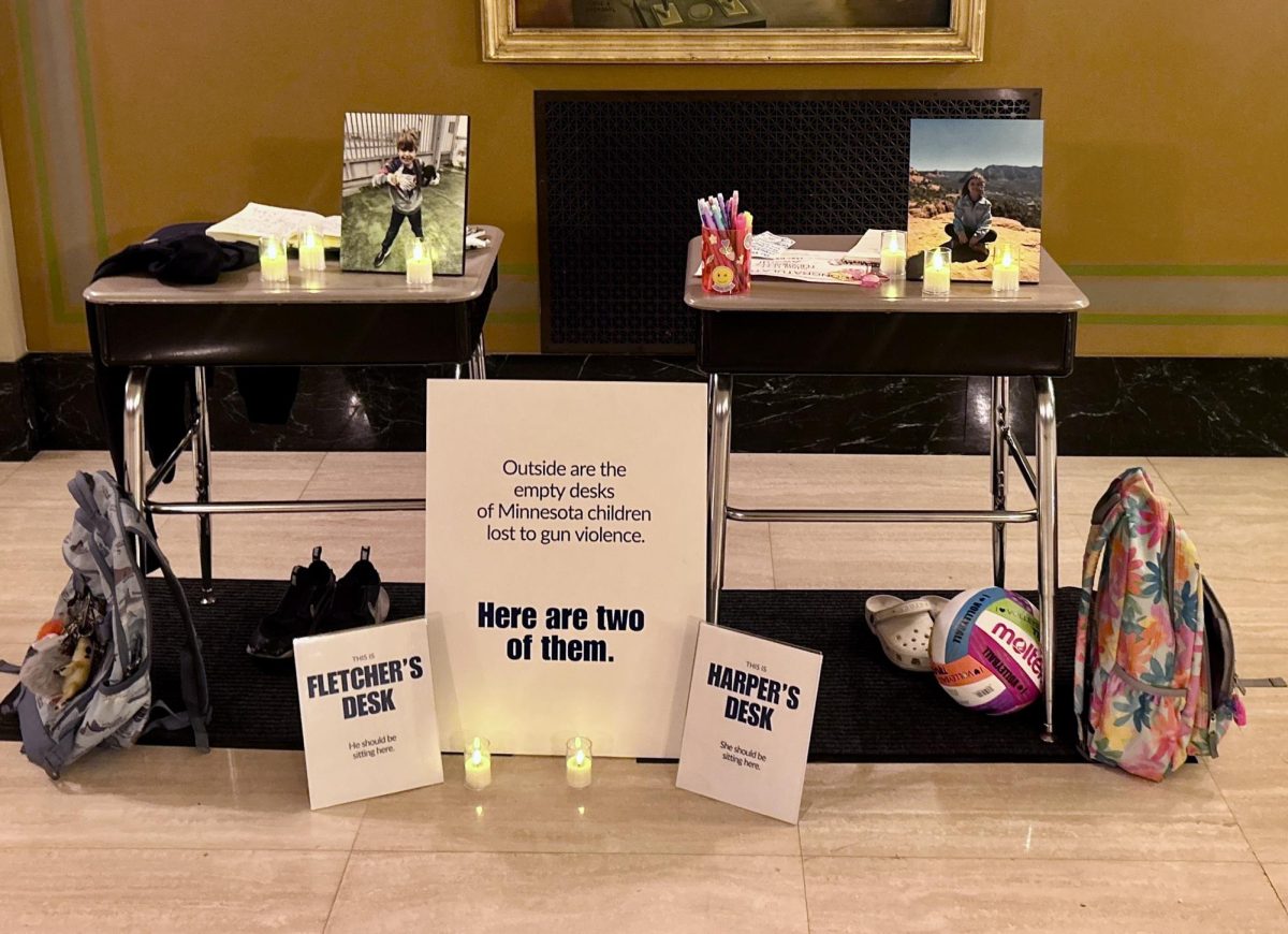 Inside the Minnesota Capitol, parents set up the desks of the two students killed in the Minneapolis Annunciation Catholic School shooting.
