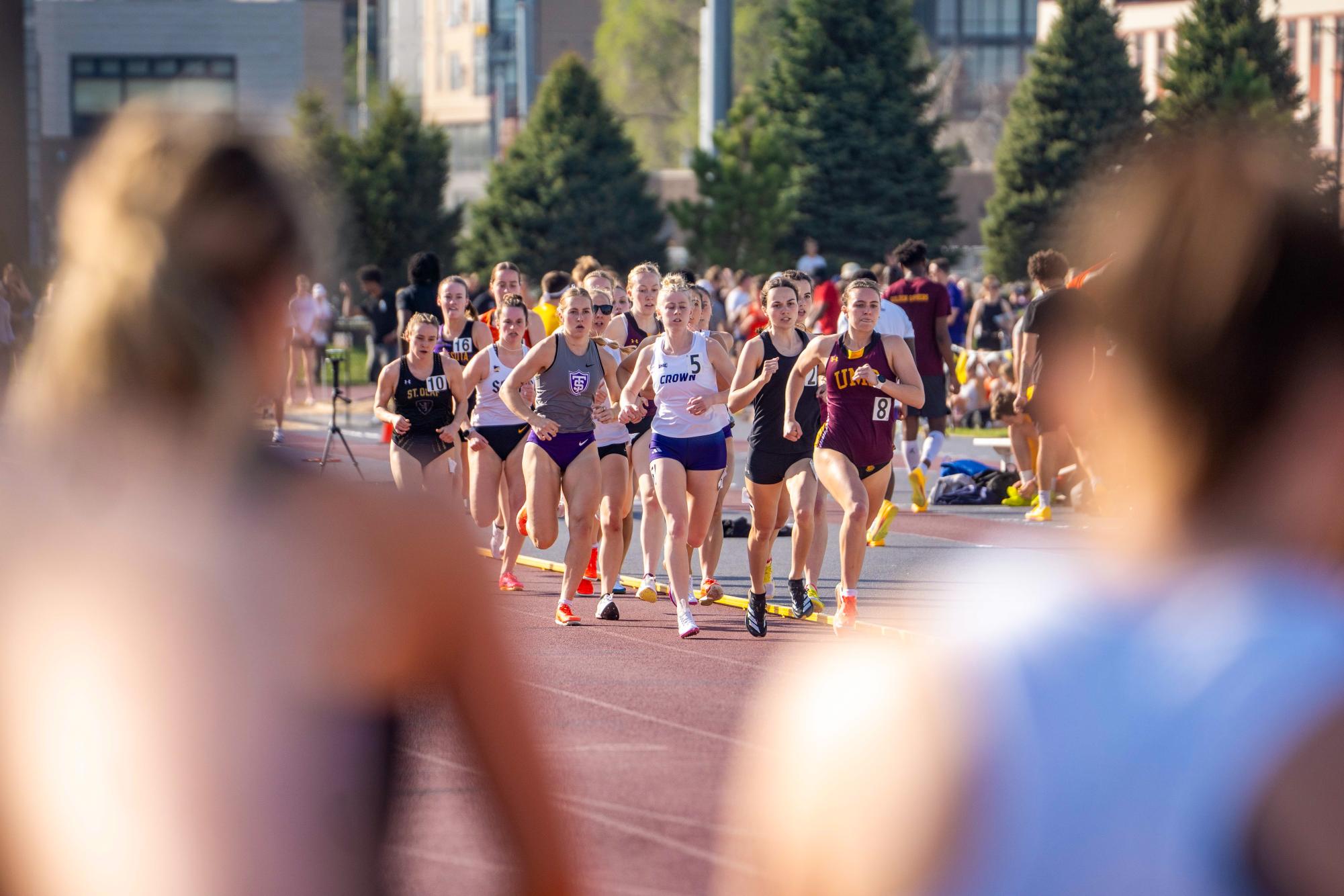 The 800 is run in two laps and there are multiple heats. Athletes in heat 2 look at the runners in heat 1 as they run in a pack and prepare to start their second and last lap of the race, April 22 2026.