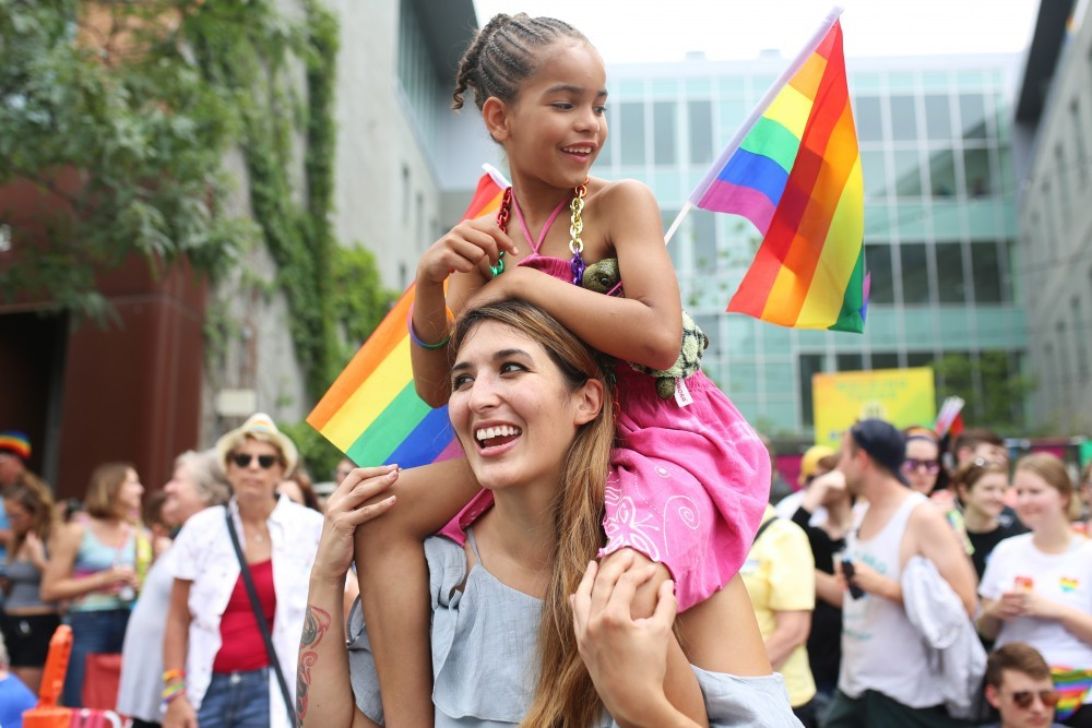 Natalie Deeble and daughter Saniya watch as the Pride Parade marches down Hennepin Ave in Minneapolis on June 24, 2018.