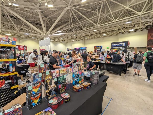 Attendees browse trading card and merchandise booths on the convention floor during Collect-A-Con at the Minneapolis Convention Center on July 18, 2026.